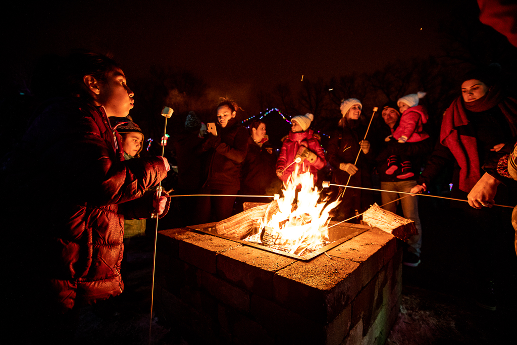 A group of children roasting marshmallows by a fire