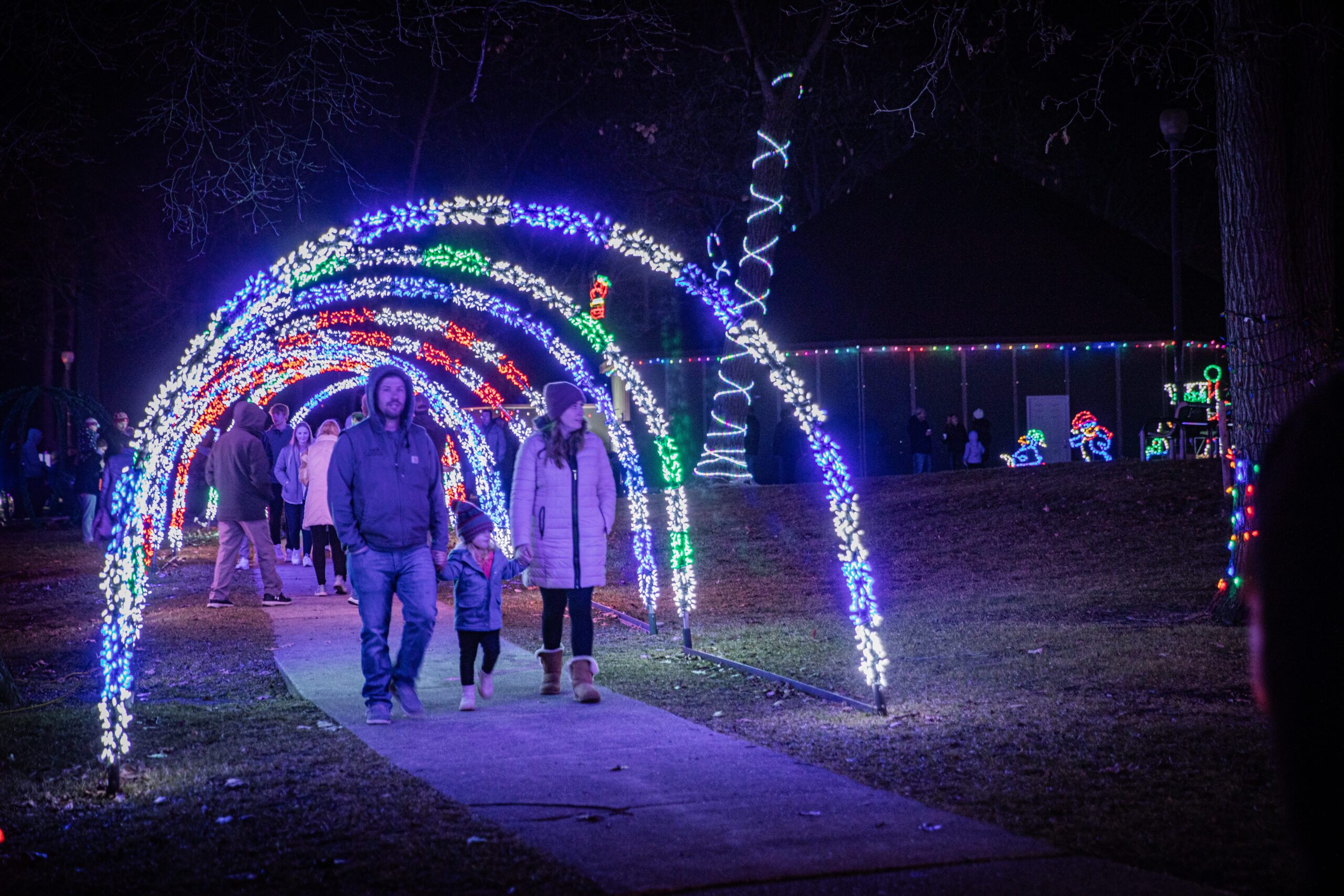 Family walking through a lighting arch
